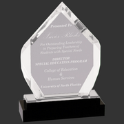 Acrylic award with engraved text on a black base against a dark gray background