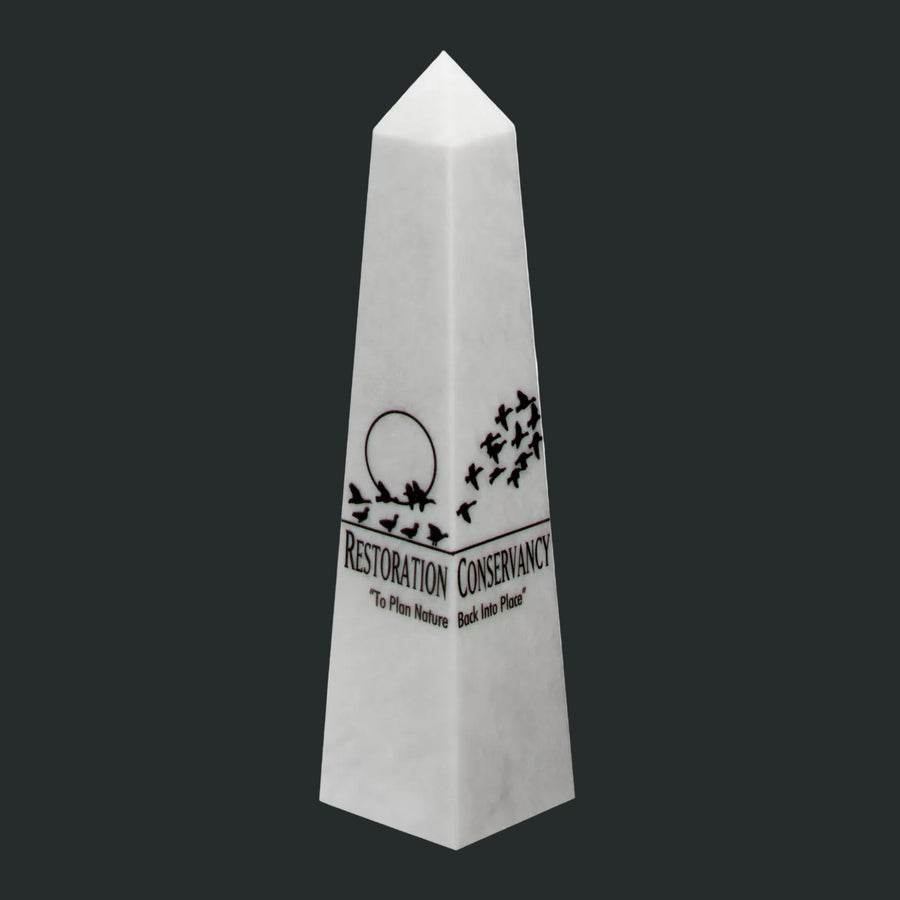 White obelisk with black text and design on a gray background