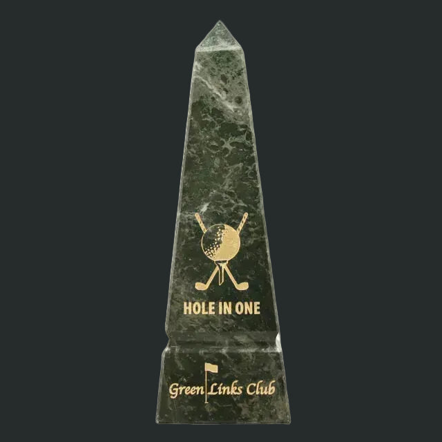 Green marble obelisk with gold engraving of a golf ball and clubs, and 'Hole in One' text on a white background.